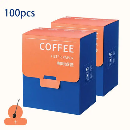 Two vibrant orange and blue decorbites coffee filter bags made of cardboard for white disposable kitchen pour over use