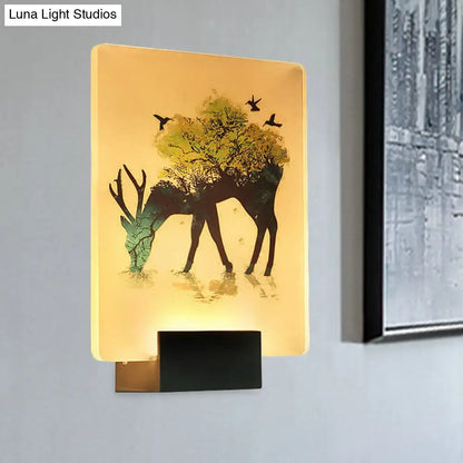 Warm-toned white elk tree led wall sconce with deer silhouette and foliage, illuminated for living room use