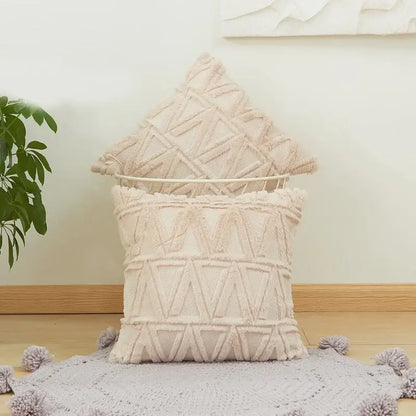 Cream-colored embroidered diamond cushion cover with geometric triangle patterns and fringed edges for living room decor