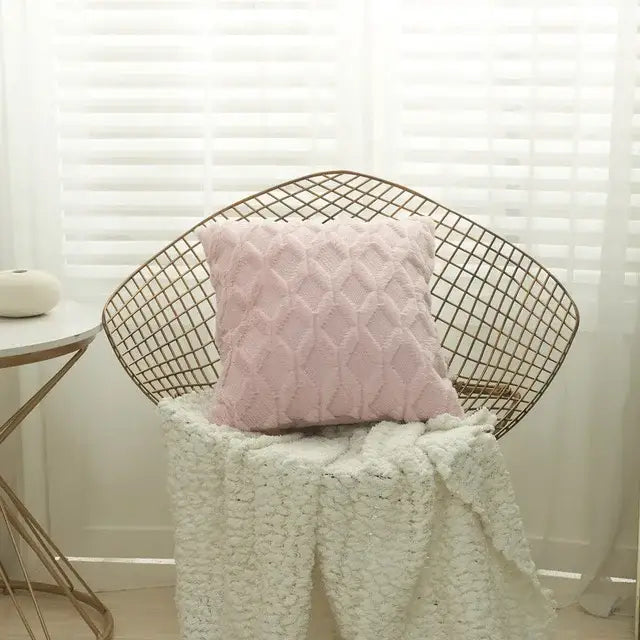 A soft pink embroidered diamond cushion cover with a textured pattern on a wire-frame chair for living room decor