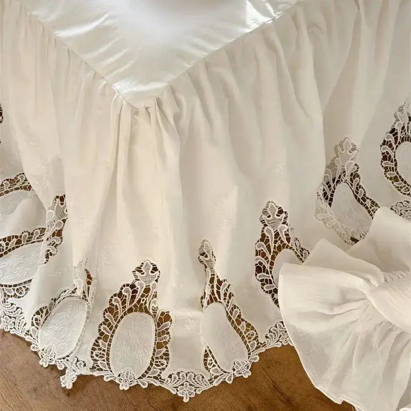 White embroidered lace cotton ruffles bedding set featuring a white ruffled bed skirt with delicate lace appliqués