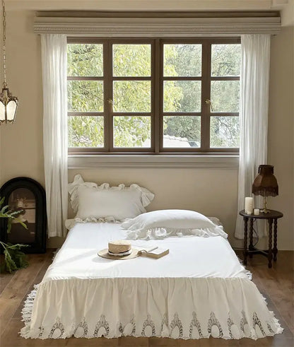 White embroidered lace cotton ruffles bedding set featuring a white ruffled bed skirt with black delicate embroidery