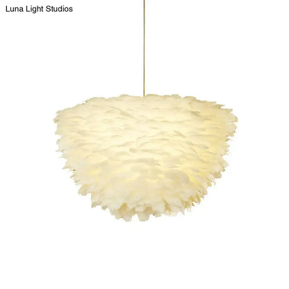 Soft cream-colored feather accents on a white floral pendant chandelier for elegant dining room lighting