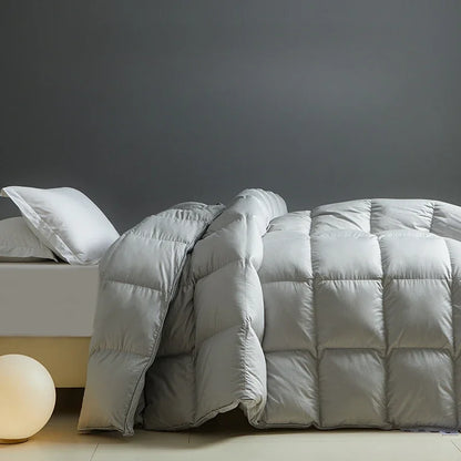 Light gray quilted white goose down comforter with plush texture and subtle sheen for autumn winter use