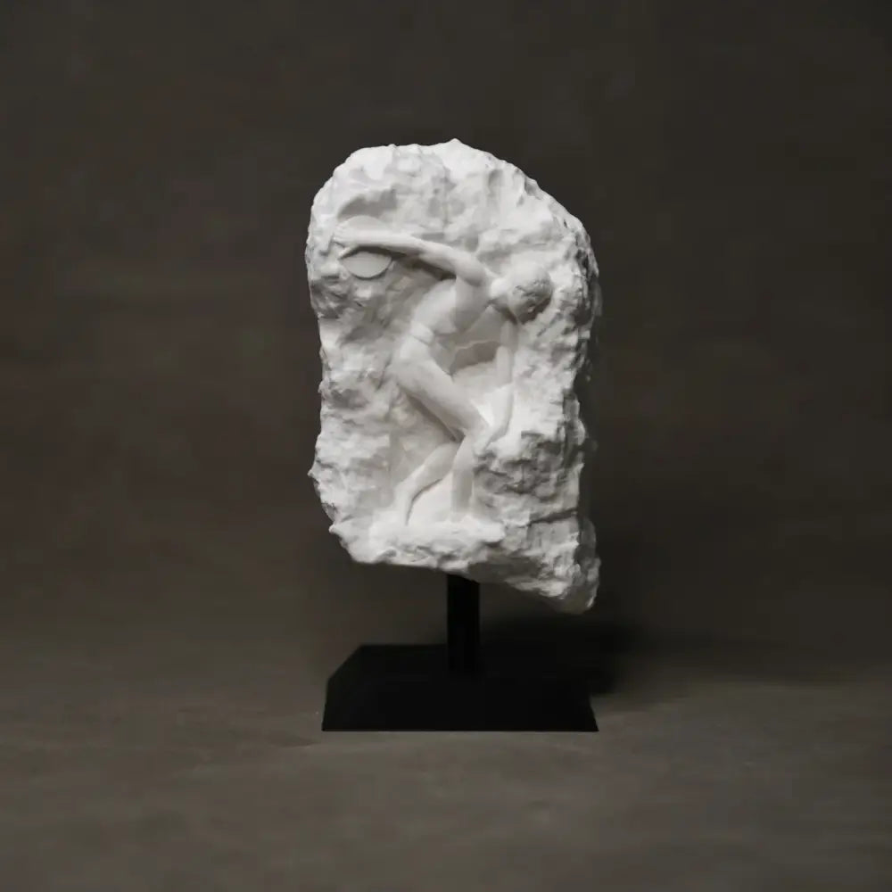 White marble discus throwing nude sculpture with expressive detail mounted on black pedestal for home decor