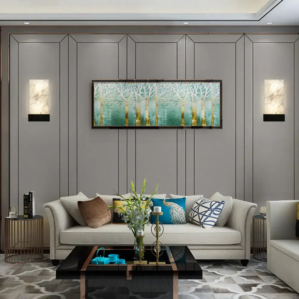 Rectangular framed painting of stylized trees with white branches and gold trunks above white marbled glass and gold wall sconce e26 e27 light