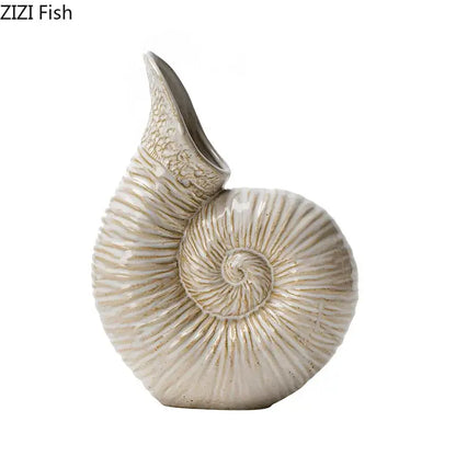 Cream-colored decorbites conch ceramic vase shaped like a nautilus shell with intricate ridged detailing for decor