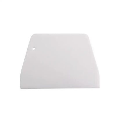 White plastic dough cream cake cutter spatula with rounded top edge and small hole for kitchen baking use