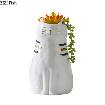 White porcelain cat vase with gold trim featuring black and gold stripes holding colorful succulents decorbites cat vase