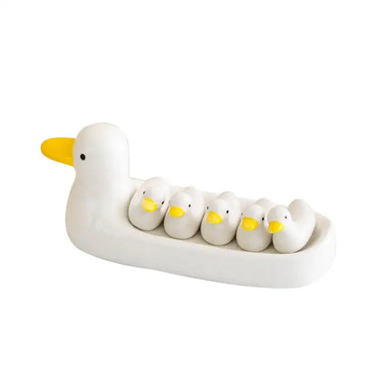 White porcelain duck chopstick holder tray featuring a ceramic dish with five smaller white ducks with yellow beaks nestled inside