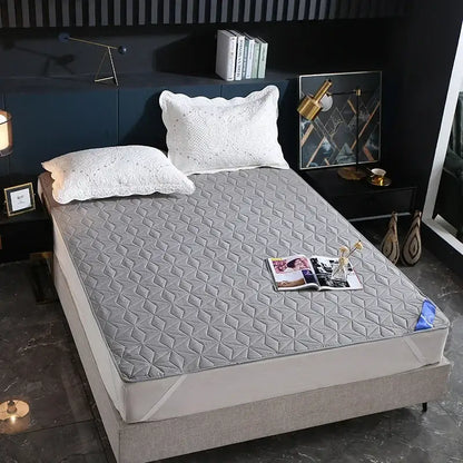 Gray quilted bed protector pad with geometric diamond pattern offering waterproof protection for bedrooms