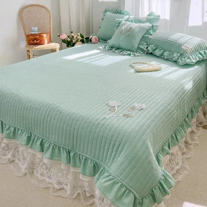 Mint green quilted bedspread coverlet with delicate white lace trim and embroidered floral details for bedroom use