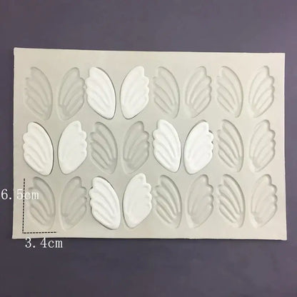White silicone cake mold with leaf-shaped cavities arranged in three rows ideal for swan neck decorbites 3d wings design