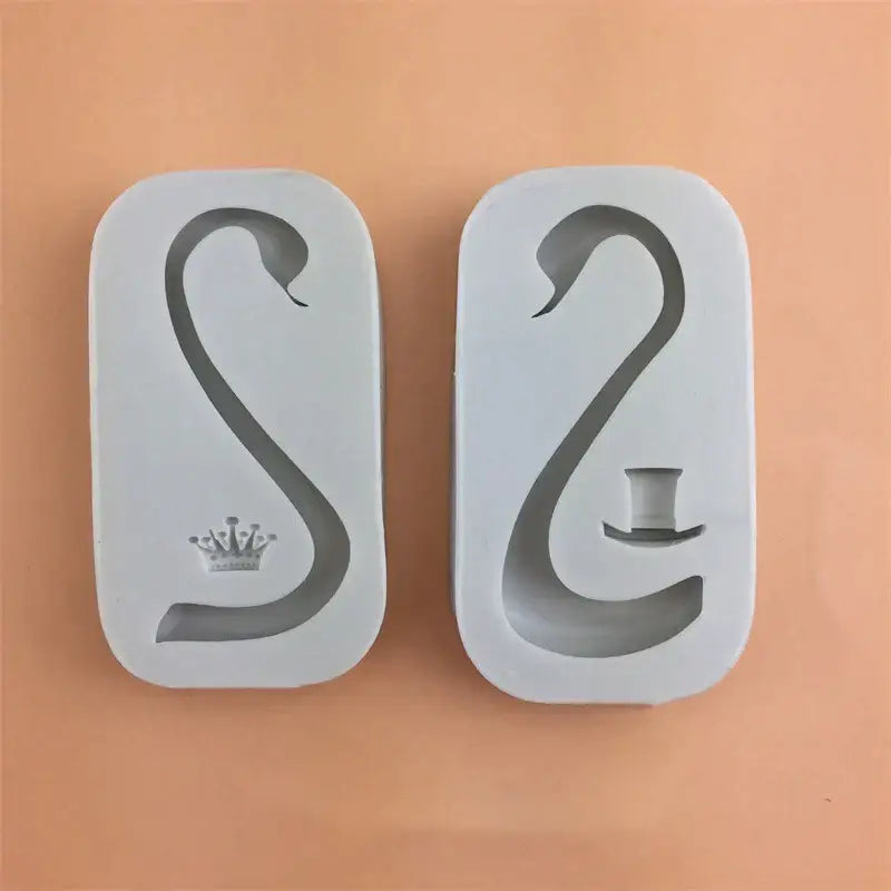Two white silicone cake molds shaped like swans with swan neck design featuring decorbites 3d wings decor elements