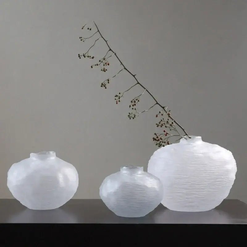 Three translucent white glass pleats vases with textured rounded surfaces and narrow necks for living room decor