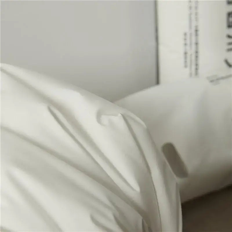 White textured cotton rectangle neck pillow with soft draped folds for bedroom bedding and neck support