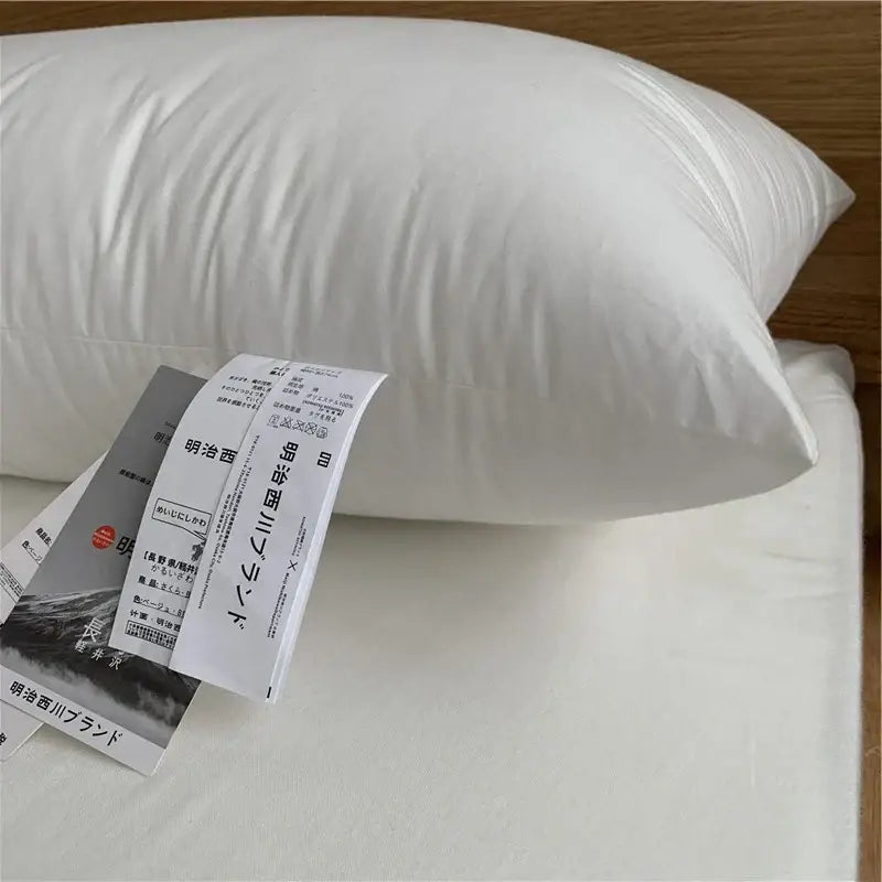 White cotton rectangle neck pillow with smooth glossy fabric and soft plump shape for bedroom bedding use