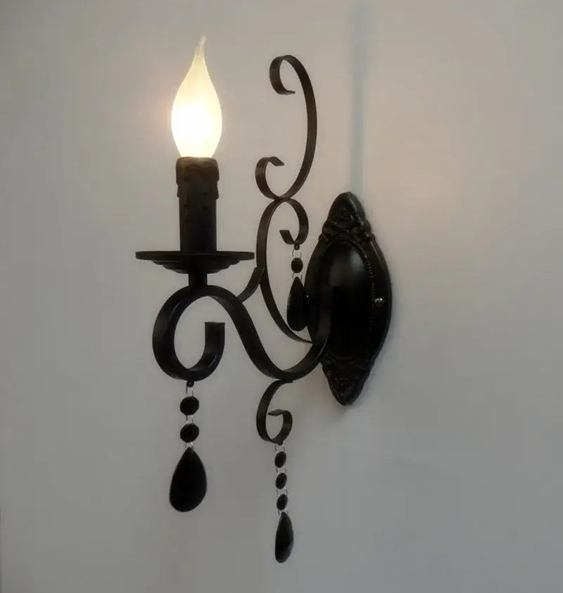 Black wrought iron wall lamp with candle-style design and dangling glass beads for decorbites crystal deco loft use