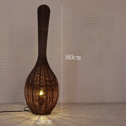 A tall dark brown woven rattan floor lamp with slender neck and bulbous base perfect as decorbites bamboo floor lamp