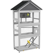 Gray wooden outdoor bird aviary by DecorBites with black roof and wire mesh panels featuring small mid-level door