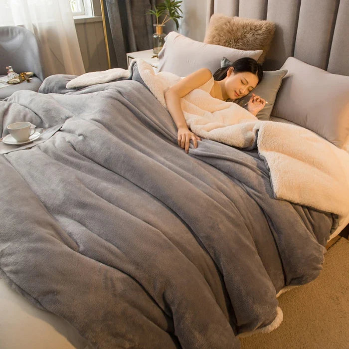 Soft gray and cream two-tone wool throw blanket with plush quilted fleece texture for winter bed and camping use