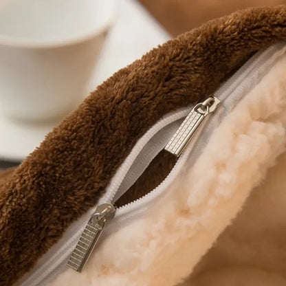 Brown plush fleece-lined zipper pouch with cream interior and silver zippers on a wool throw blanket for winter warmth