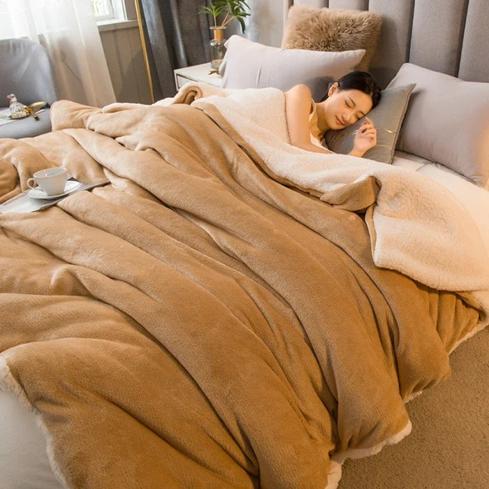 Warm plush beige and cream-colored fleece wool throw blanket with soft cozy texture for winter bed and camping use