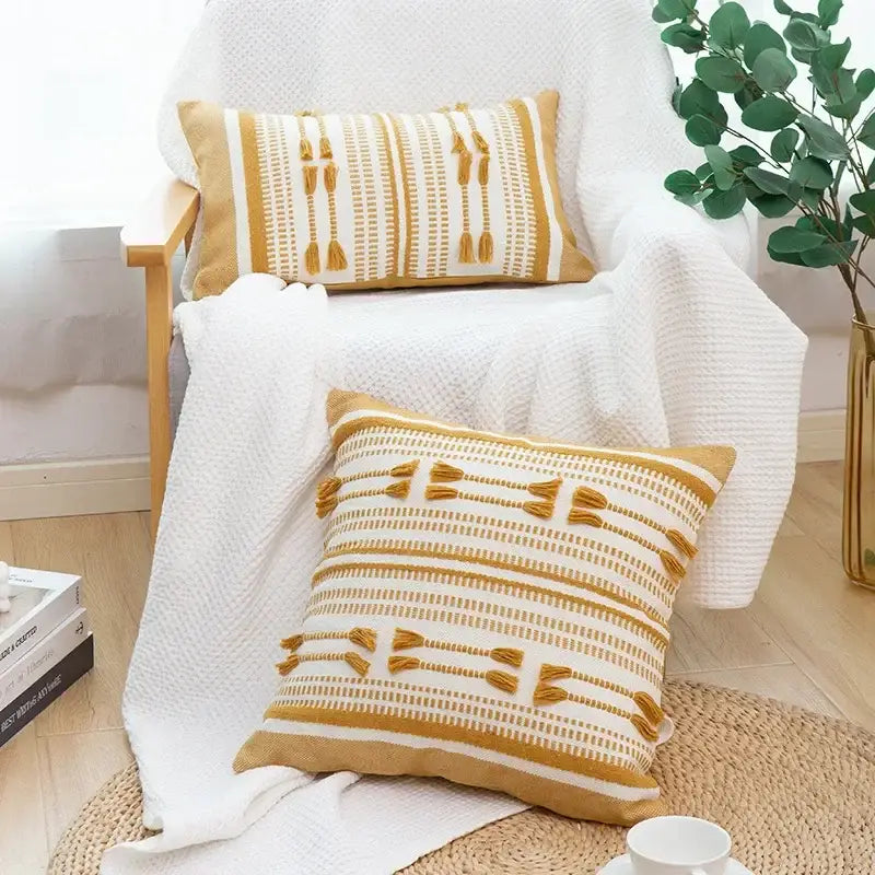 Two mustard-yellow and white woven geometric tassels cushion covers with tassel accents for living room decorbites decor