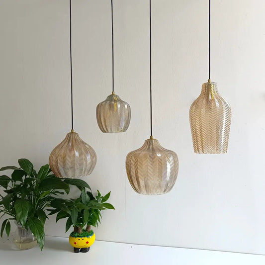 Four gold-toned woven glass pendant lights with black cords in Nordic style for kitchen and dining room lighting