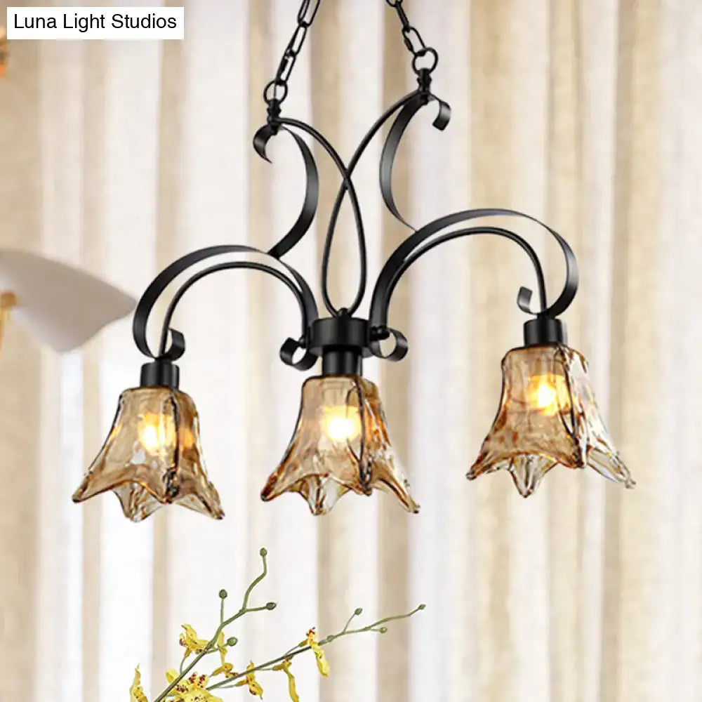 Decorbites black flower island ceiling light with black wrought iron frame and three amber textured glass shades for dining room