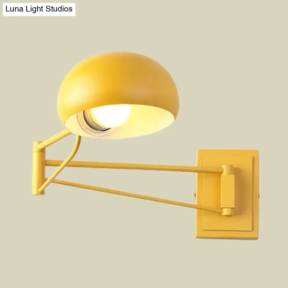 Yellow adjustable metal wall sconce with bowl shade and articulated arm for bedroom lighting