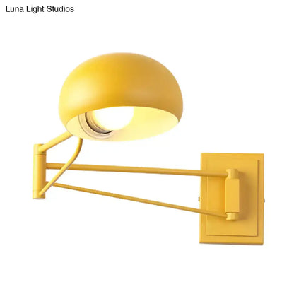 Yellow adjustable metal wall sconce with bowl shade and articulated arm for bedroom wall mounting