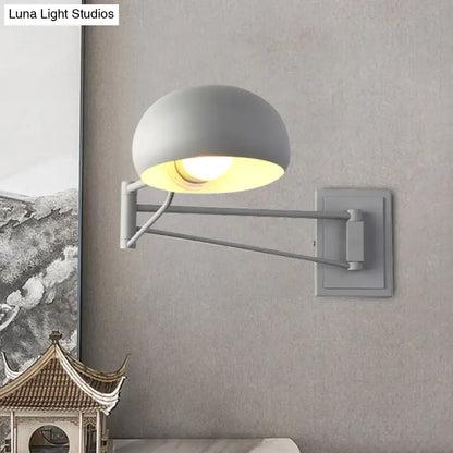 Gray adjustable metal wall sconce with bowl shade and articulated arm for versatile bedroom lighting
