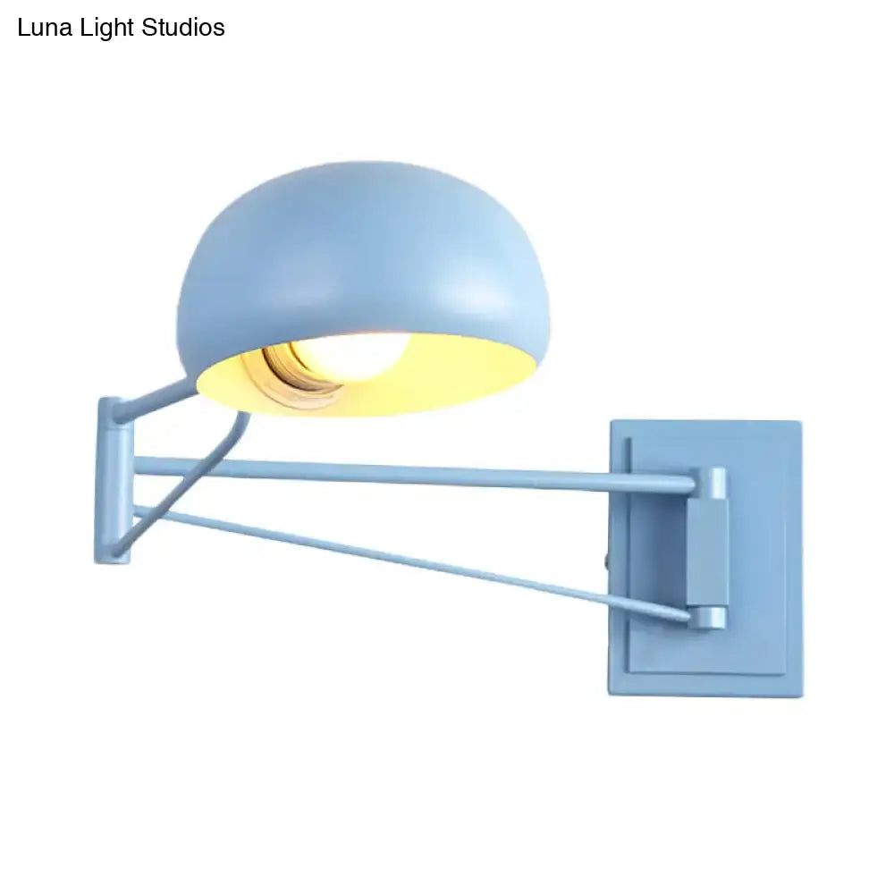 Light blue adjustable metal wall sconce with dome-shaped bowl shade and metallic arm for bedroom use