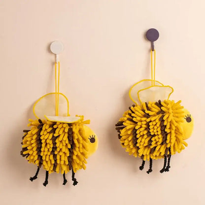 Yellow and black bee shape chenille hand towels with fuzzy texture and black legs hanging on hooks for bathroom use