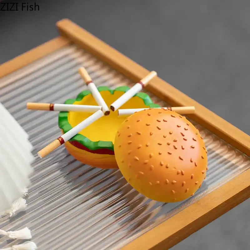 Orange plastic cartoon burger ashtray with green and yellow details for office table decor by decorbites cartoon burger