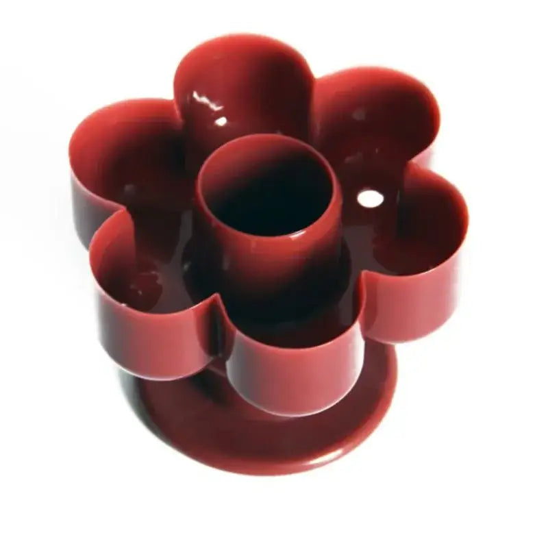Red plastic flower-shaped cookie cutter with five rounded petals in a yellow and white donut cutter baking tools kit