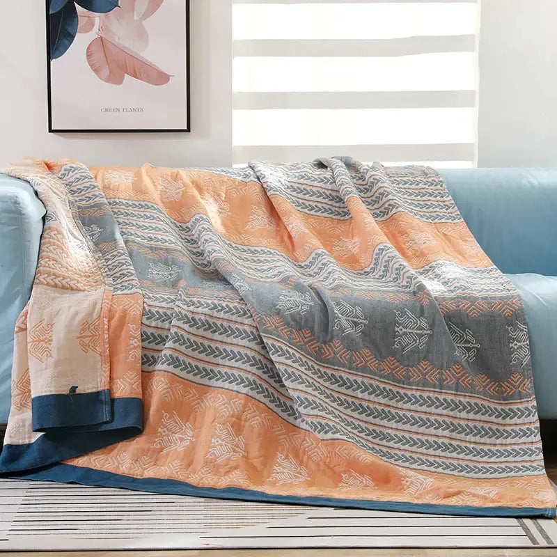 Cozy quilted cotton stripe gauze throw blanket in orange and gray with white geometric designs for summer use