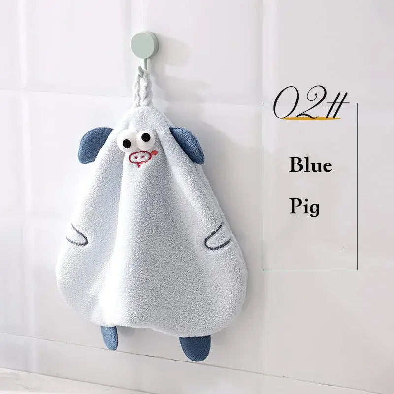 A soft light blue plush cartoon pig hand towel with darker blue ears and feet by decorbites cartoon pig for bathroom or kitchen decor