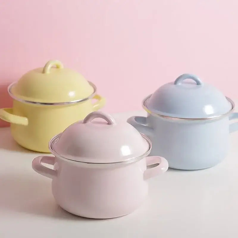 Pastel-colored enamel stock pots with rounded lids and handles in soft yellow, light blue, and pink cooking pot finishes