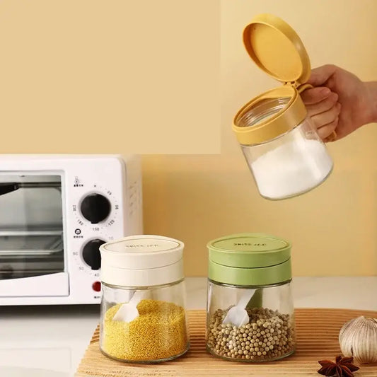 Yellow flip top glass seasoning jar with spoon featuring clear glass seasoning jar filled with white sugar and yellow lid