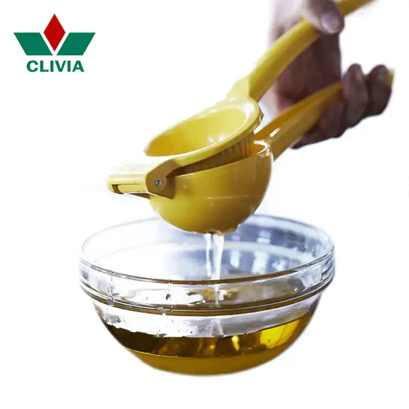 Yellow hand press citrus juicer made of aluminum squeezing juice into a glass bowl for kitchen use