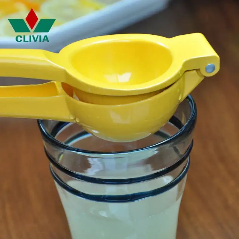 Bright yellow aluminum hand press citrus juicer citrus reamer resting atop a glass for efficient juice extraction