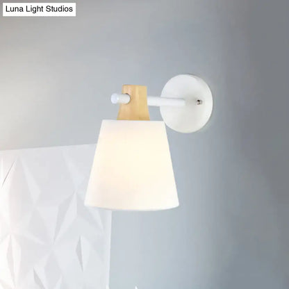 Minimalist wall light with macaron fabric shade, white ceramic base, and wood accent arm for bedroom lighting
