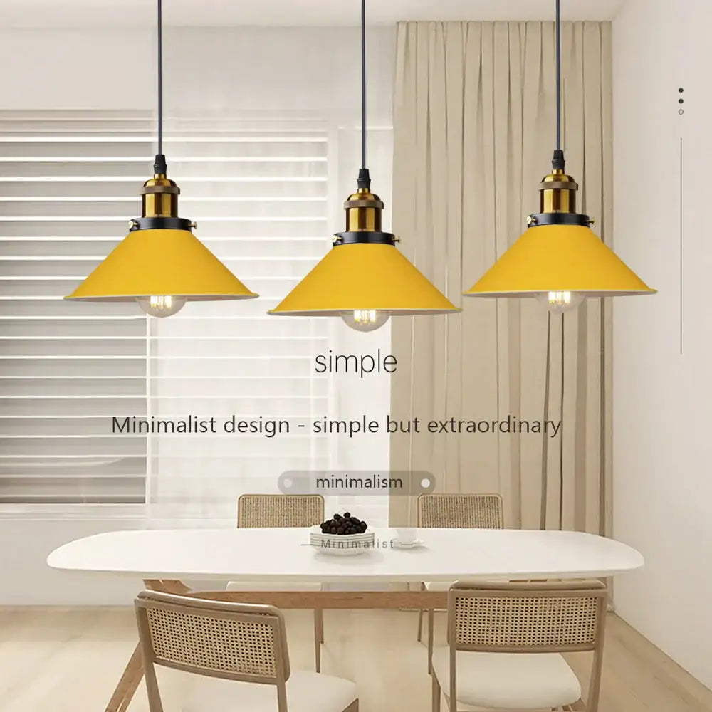 Three bright yellow conical pendant lights with brass fixtures decorate a dining room in decorbites colorful nordic style