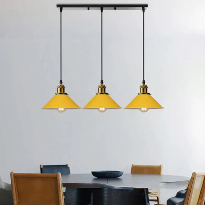 Three vibrant yellow conical pendant lights with brass fixtures hang on a black bar for colorful nordic decorbites decor