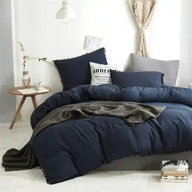 Navy blue quilted comforter with black pom-pom trim from decorbites furball tasseles bedding set for stylish decor