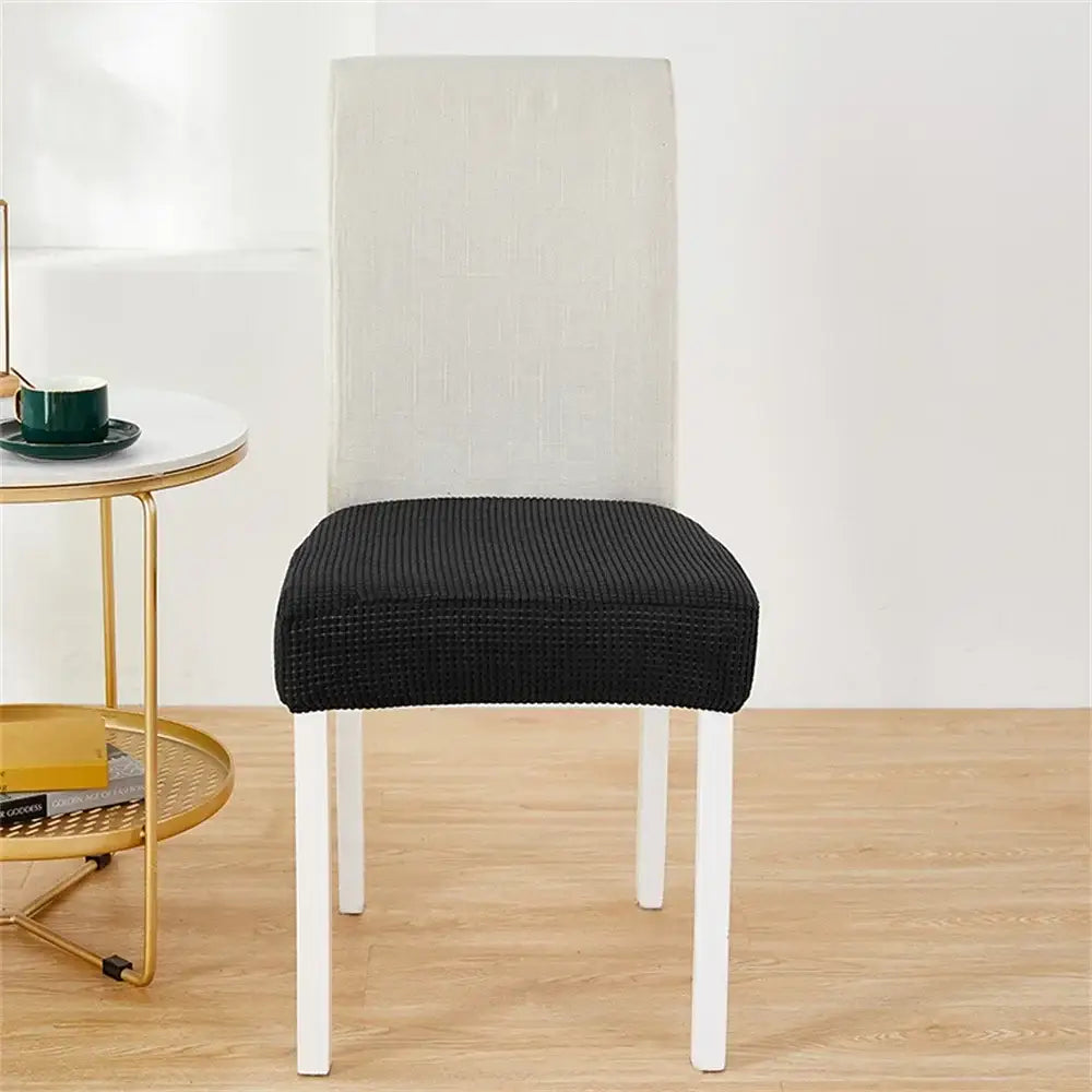 Black ribbed stretch chair cover over white dining chair for seat protection as a fleece chair cover alternative