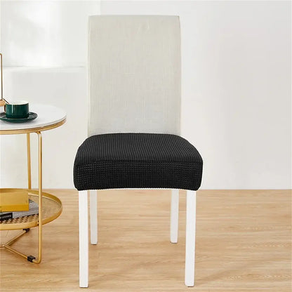 Black ribbed stretch chair cover over white dining chair for seat protection as a fleece chair cover alternative