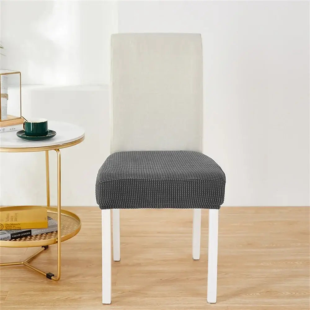 Gray textured fleece chair cover with subtle grid pattern snugly fitted for modern dining chair protection